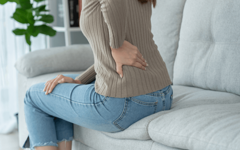 lady on sofa with back pain